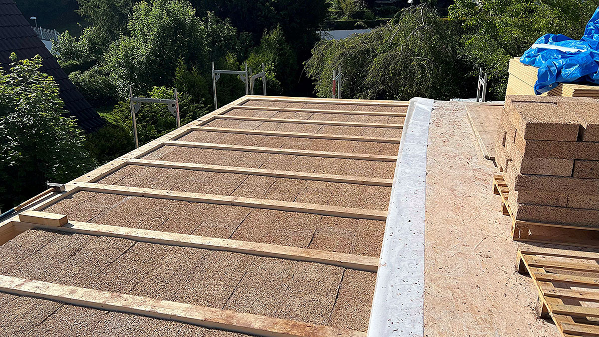 Dachfläche im Bau mit eingelegten Dämmplatten aus Naturmaterial und vorbereiteter Unterkonstruktion für die weitere Dacheindeckung.